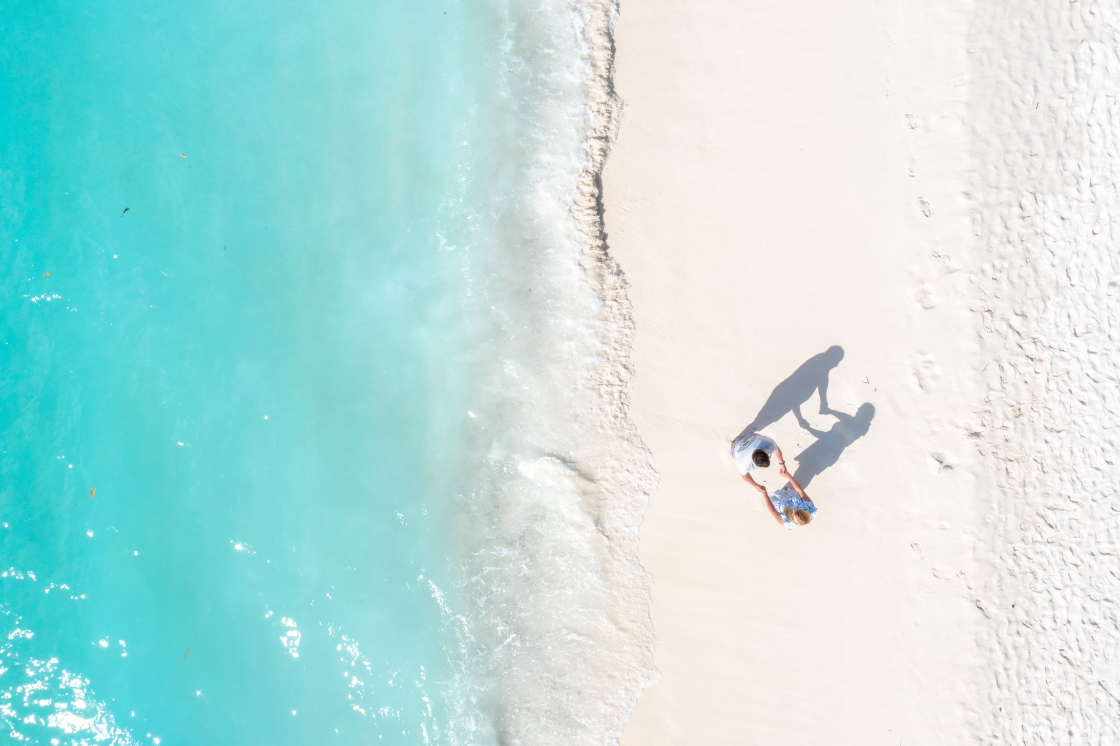 Drone Shot of a Couple Holding Hands at the Beach